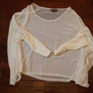 Beige sheer top with fitted sleeves.